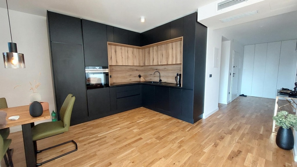 Cuisine équipée noire avec fond en bois et parquet