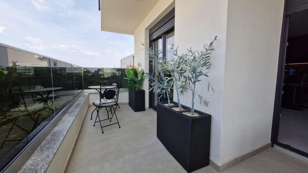 Balcon avec mobilier de bistrot et petits oliviers en jardinières