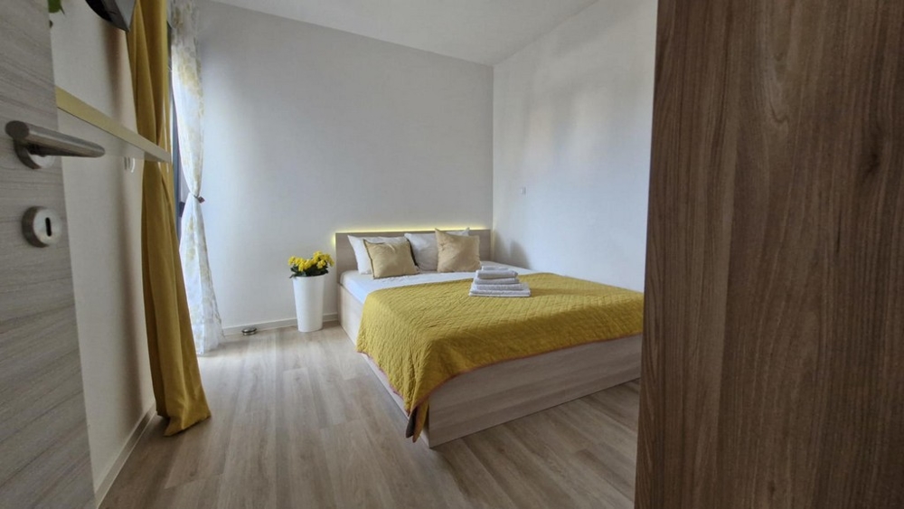 Chambre avec lit double, couette jaune et décorations