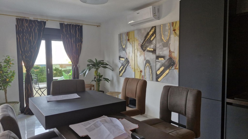 Coin repas avec table, chaises et décorations, accès au balcon