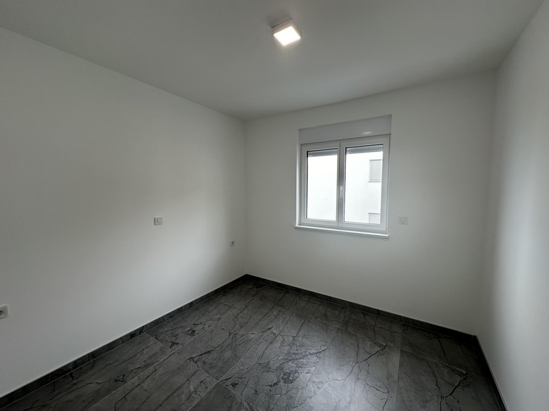 Chambre vide avec sol carrelé et une fenêtre