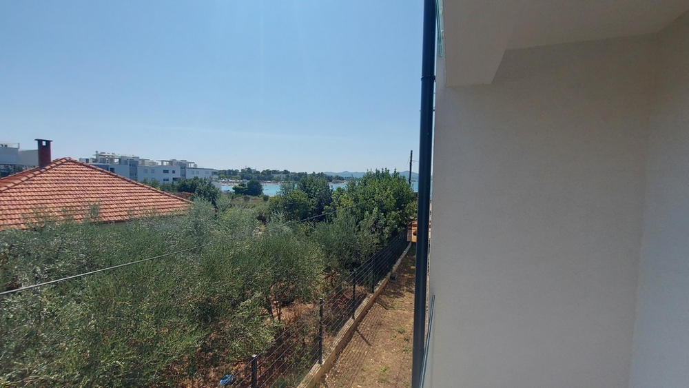 Vue le long du mur de la maison, par-dessus les oliviers, jusqu'à la baie