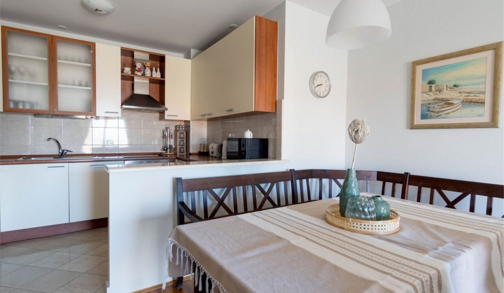 Table à manger et vue sur la cuisine de l'appartement A3462.