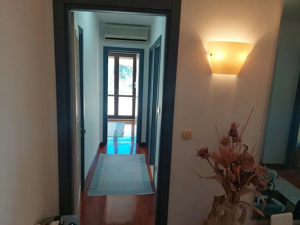 Couloir aux murs clairs et parquet, entrée à l'aménagement moderne