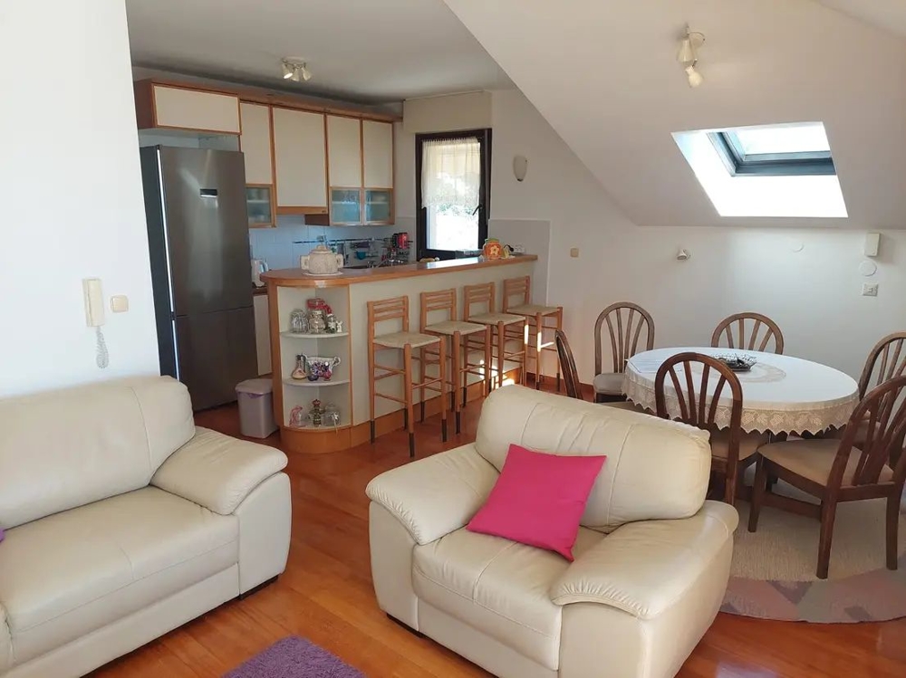 Salon convivial avec cuisine, bar et table à manger dans un appartement sous les toits