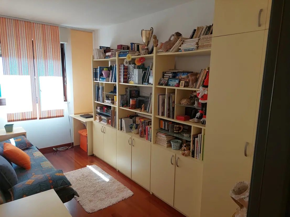 Pièce avec bibliothèques, bureau et canapé, fenêtres lumineuses
