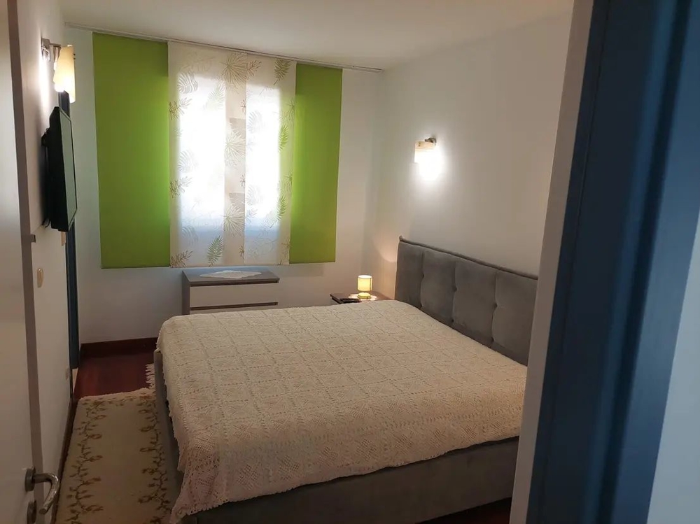Chambre avec grand lit et rideaux verts