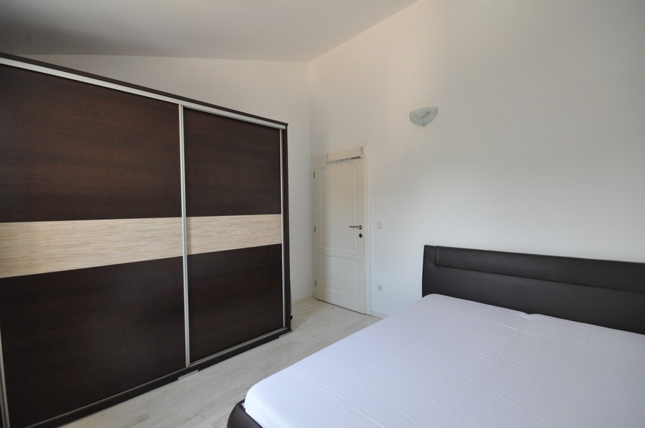 Chambre avec armoire sombre et grand lit
