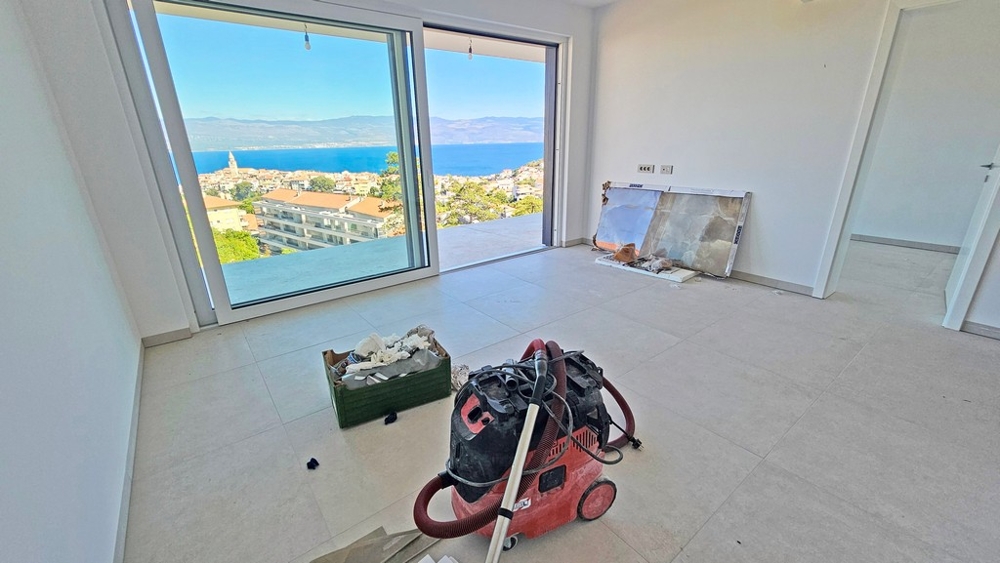 Salon avec grande façade vitrée et vue sur Vrbnik et le golfe du Kvarner