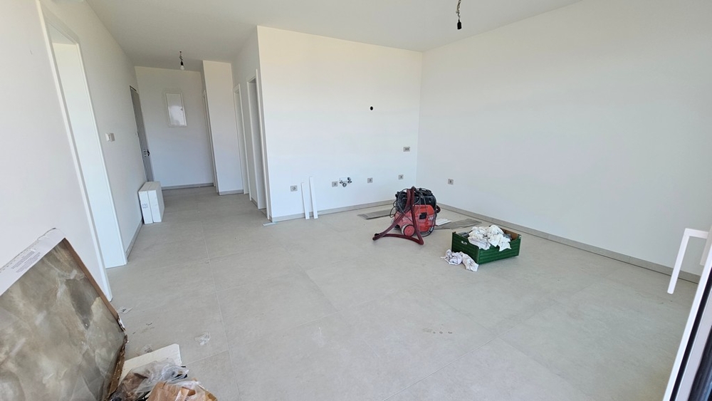 Séjour et espace repas ouverts de l'appartement neuf A3479 avant la pose de la cuisine