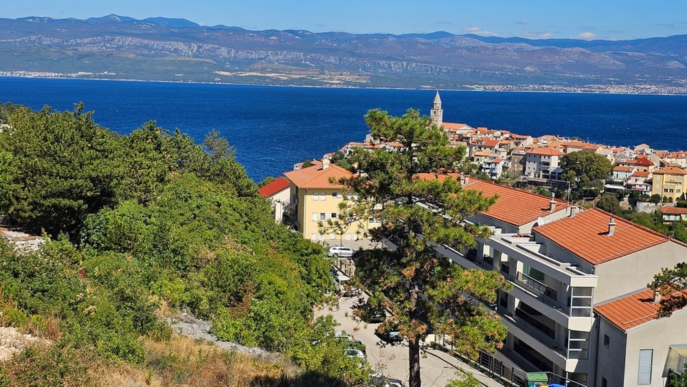 Vieille ville de Vrbnik avec clocher devant la mer et le continent, situation des appartements A3480