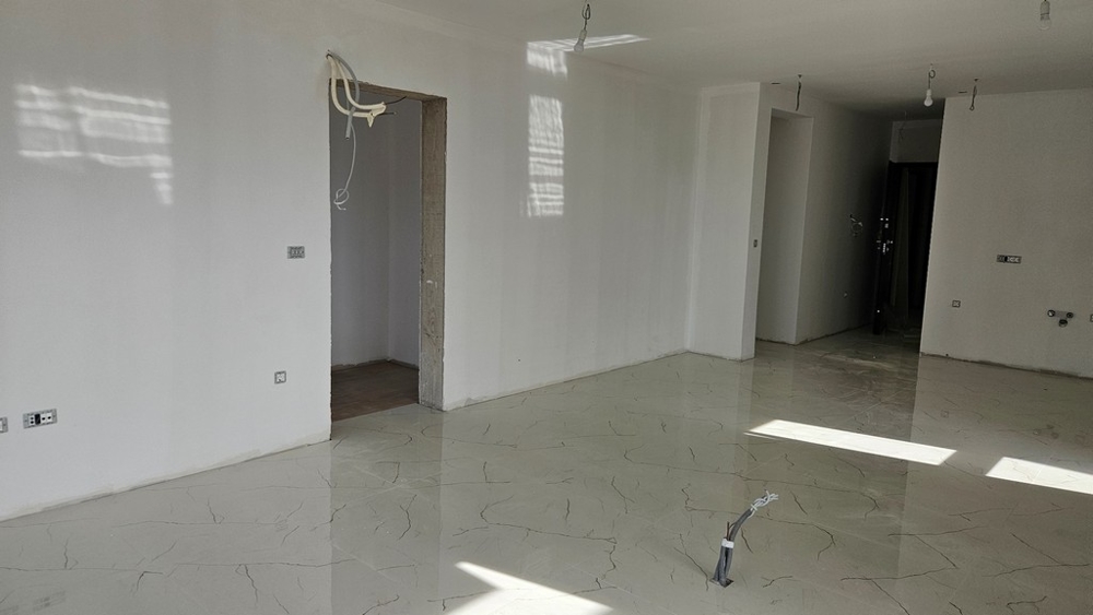 Pièce inachevée avec carrelage clair au sol, prête pour la suite des finitions