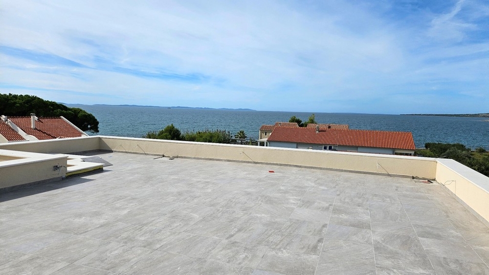Toit-terrasse avec vue panoramique sur la mer et les toits rouges des maisons en contrebas