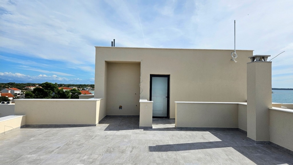 Toit-terrasse avec porte d'accès menant à un espace couvert
