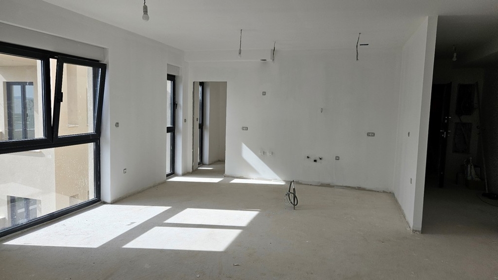 Intérieur inachevé avec beaucoup de lumière naturelle, accessible par de grandes fenêtres