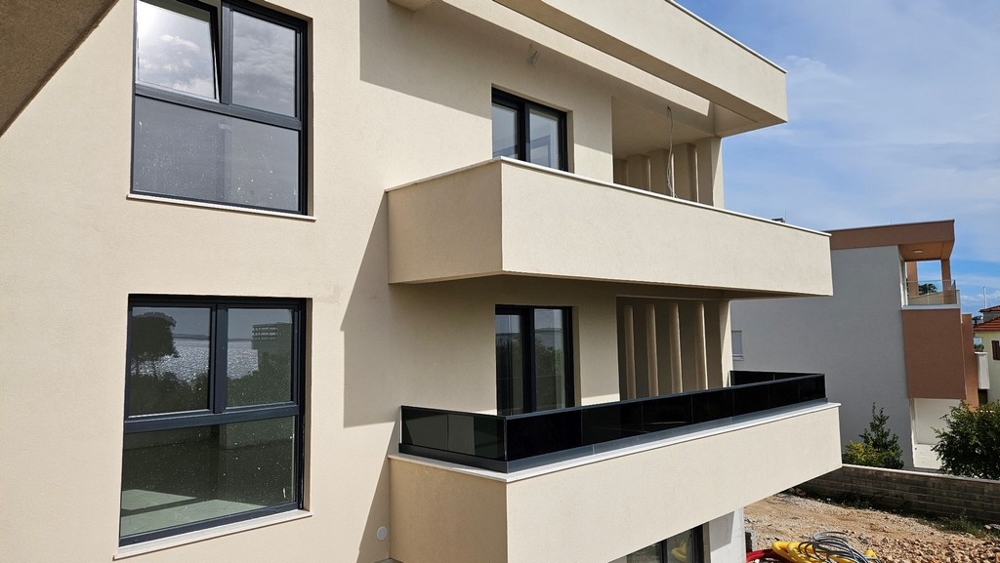 Balcons avec garde-corps en verre foncé sur la façade claire
