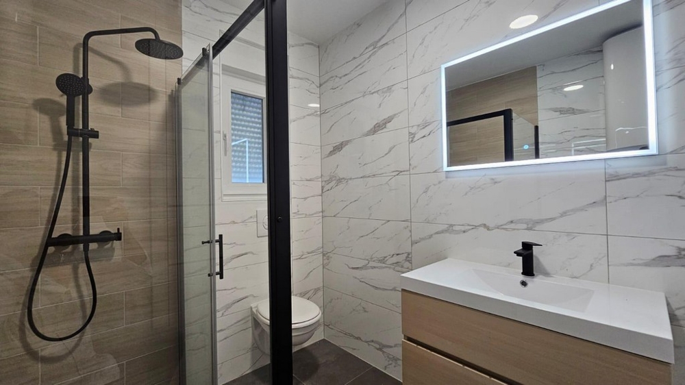 Salle de bains moderne avec douche de pluie et miroir