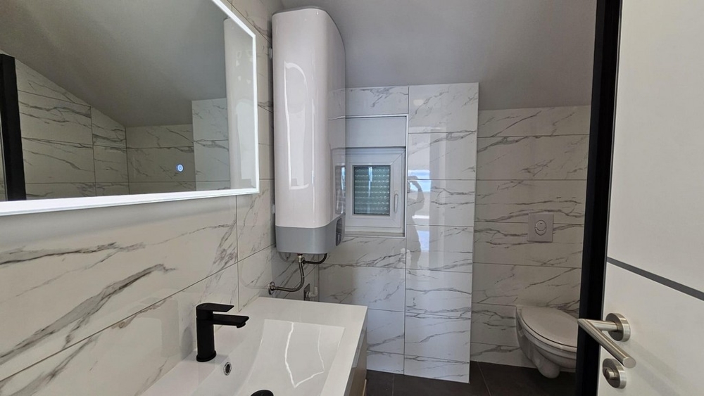 Salle de bains avec miroir, vasque et WC