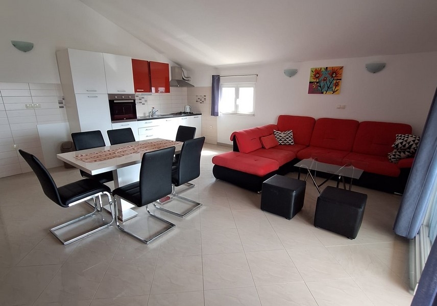 Coin repas avec cuisine et vue sur le canapé de l'appartement.