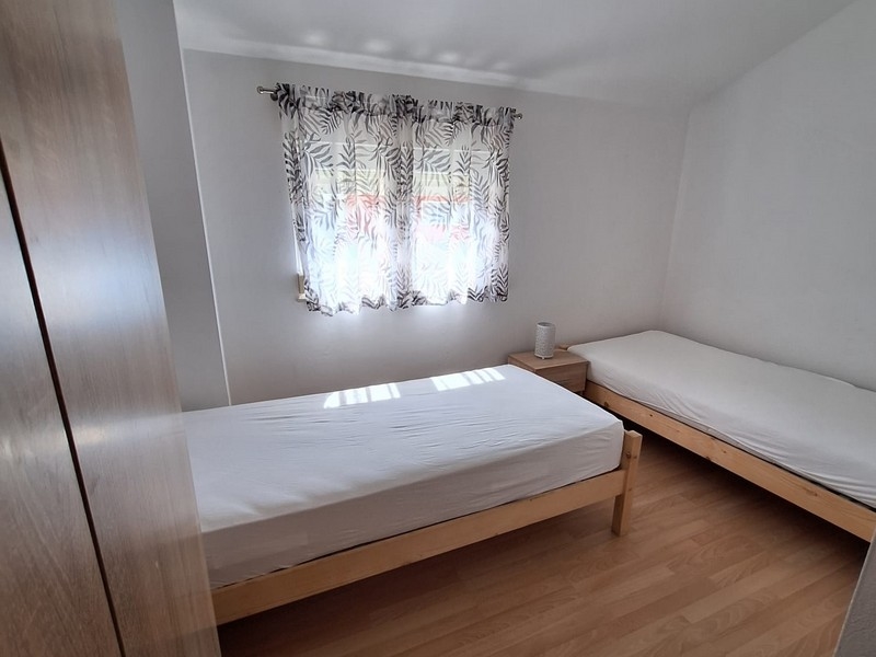 Chambre avec deux lits simples et rideaux clairs