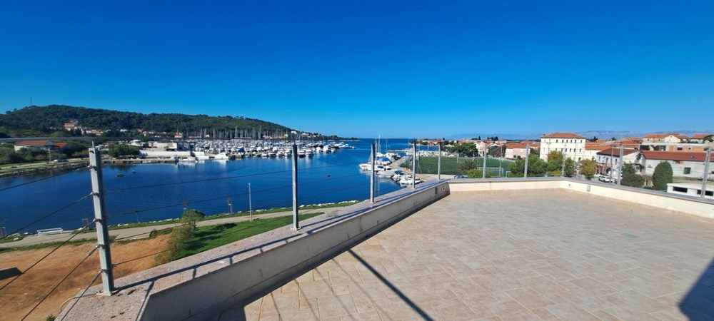 Toit-terrasse avec vue sur le port de plaisance jusqu'à la baie