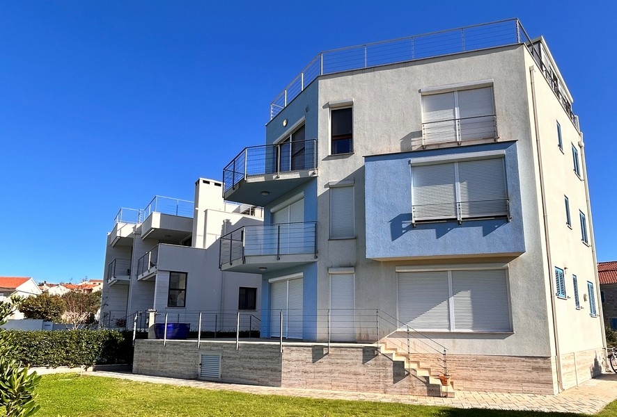 Immeuble d'habitation avec balcons et toit-terrasse au-dessus de la pelouse