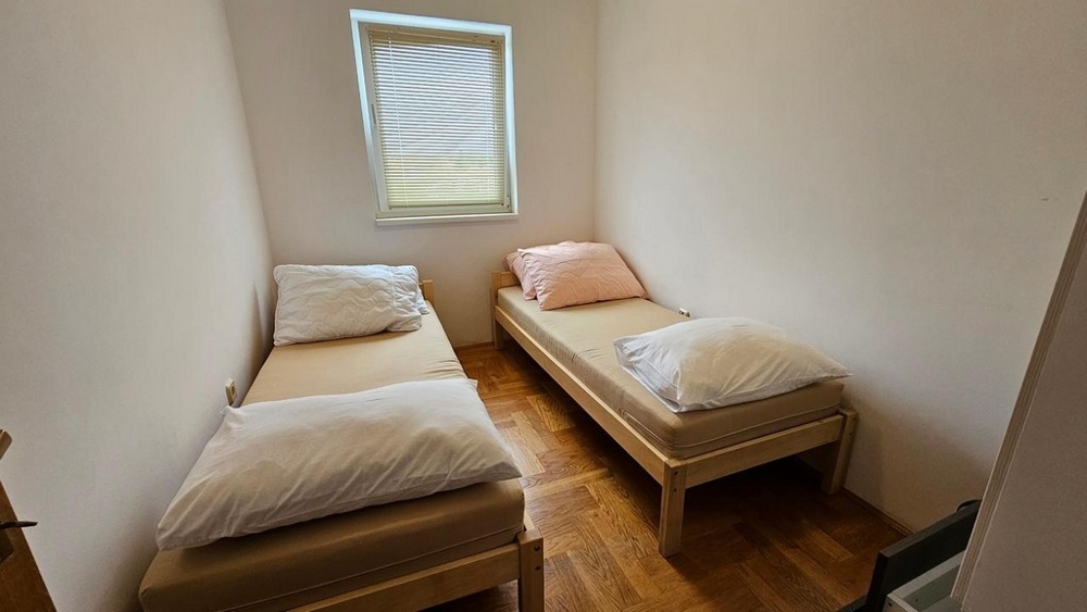 Petite chambre avec deux lits simples.