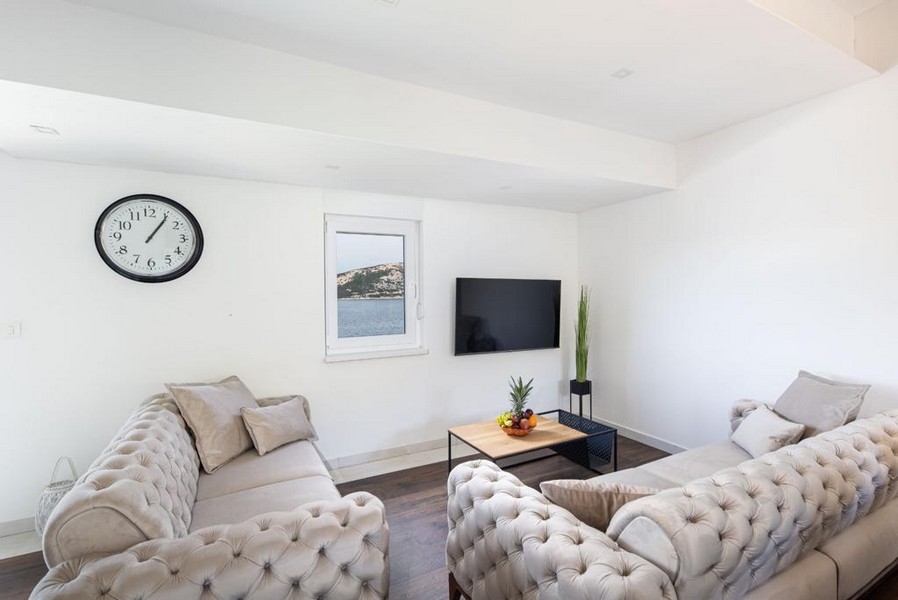 Salon avec vue mer et télévision.
