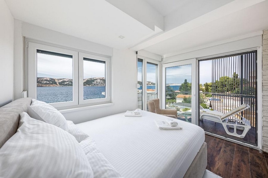 Chambre avec accès à la terrasse et vue sur la mer.