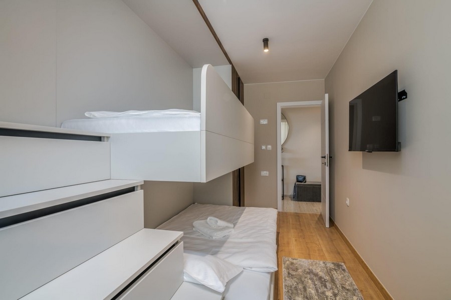 Deuxième chambre avec lit en hauteur et télévision
