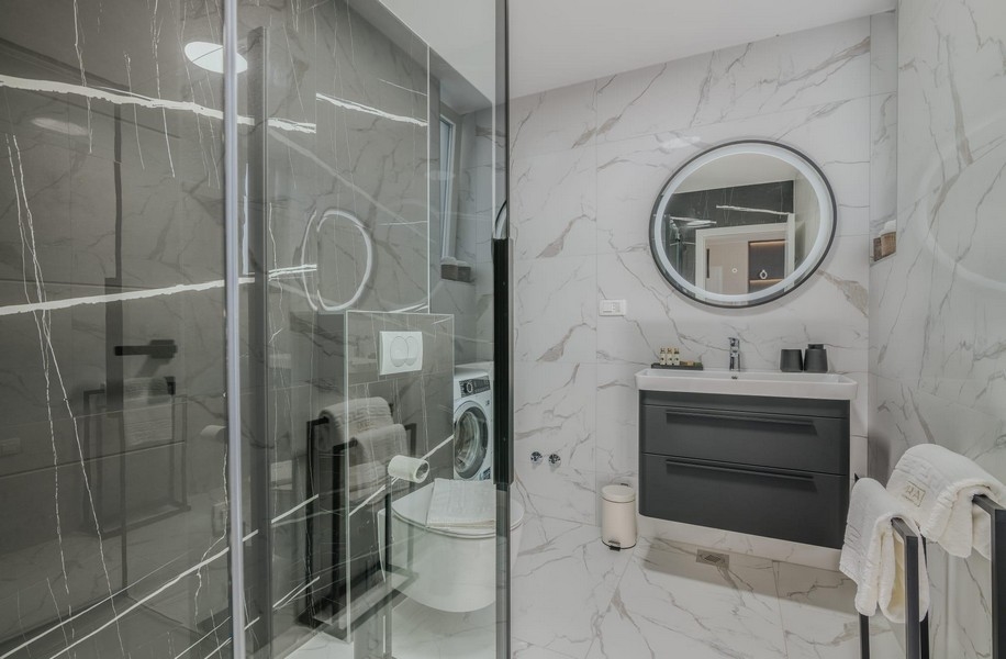 Salle de bains avec douche moderne en verre et carrelage en marbre