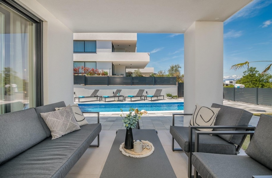 Terrasse avec vue sur la piscine et bains de soleil