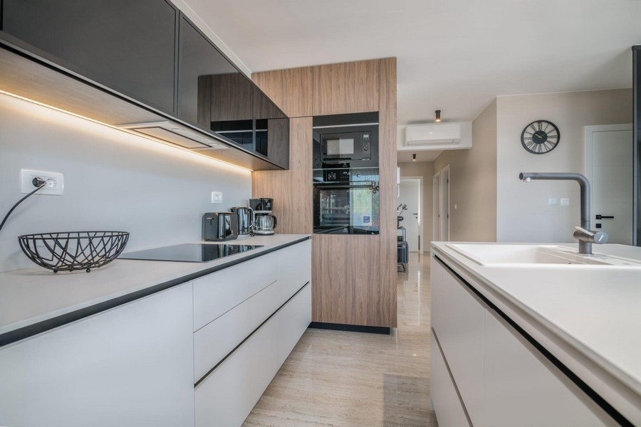 Cuisine linéaire avec façades en bois et haute brillance, éclairage LED