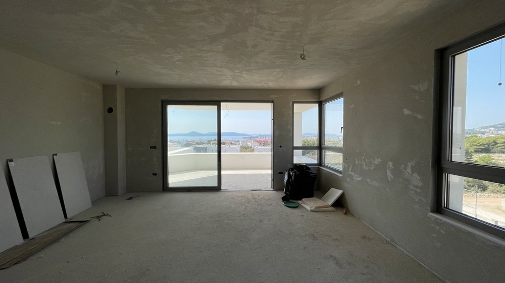 Séjour et coin repas ouverts avec façade vitrée et vue mer, penthouse A3577 en construction.
