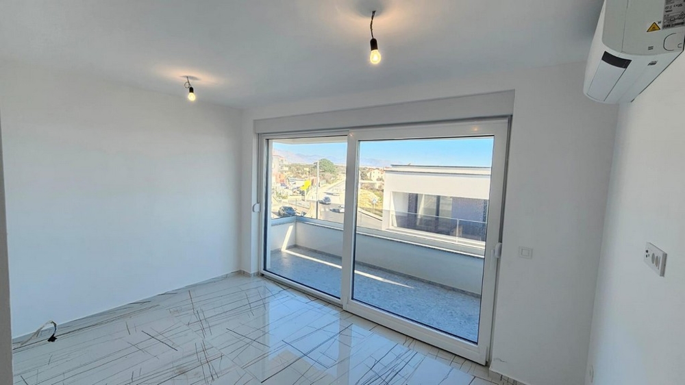 Deuxième chambre avec accès au balcon et vue sur la résidence
