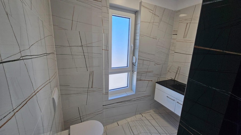 Salle de bains au carrelage moderne et avec fenêtre