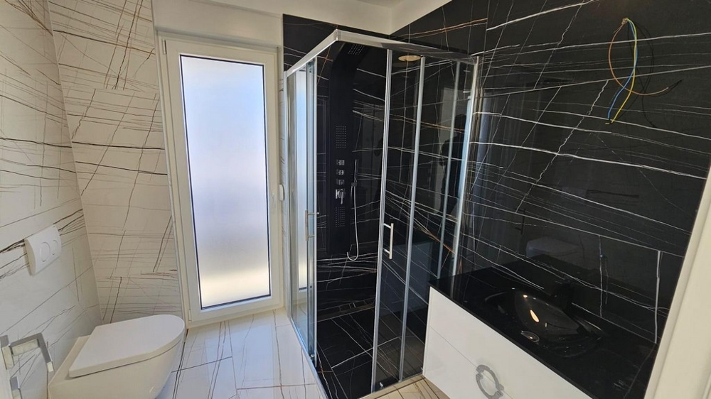 Salle de bains élégante avec douche et carrelage foncé