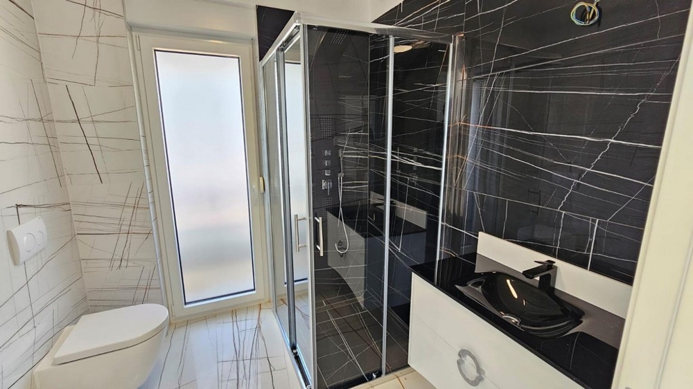 Salle de bains élégante avec douche noire et lavabo