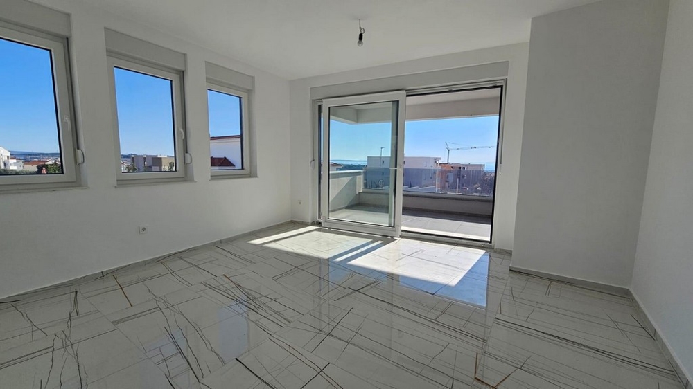 Séjour lumineux avec balcon et vue mer.