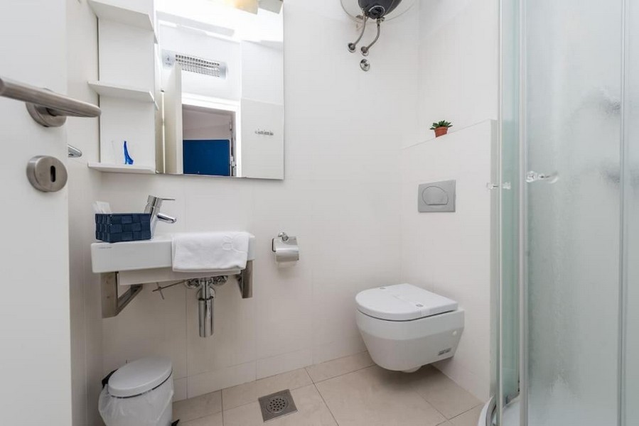 Salle de bains avec douche et carrelage blanc