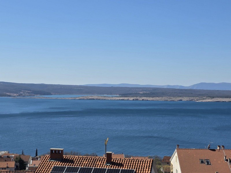 Toits de tuiles avec panneaux solaires devant la vaste baie