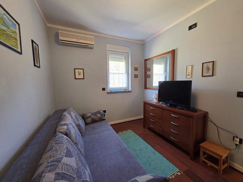 Chambre avec canapé, commode et télévision