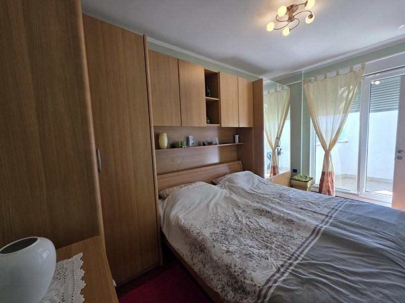 Chambre principale avec placard encastré et accès au balcon
