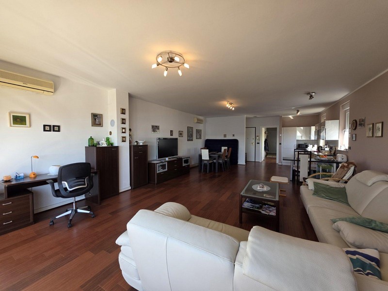 Séjour lumineux avec parquet, canapé en cuir et vue mer
