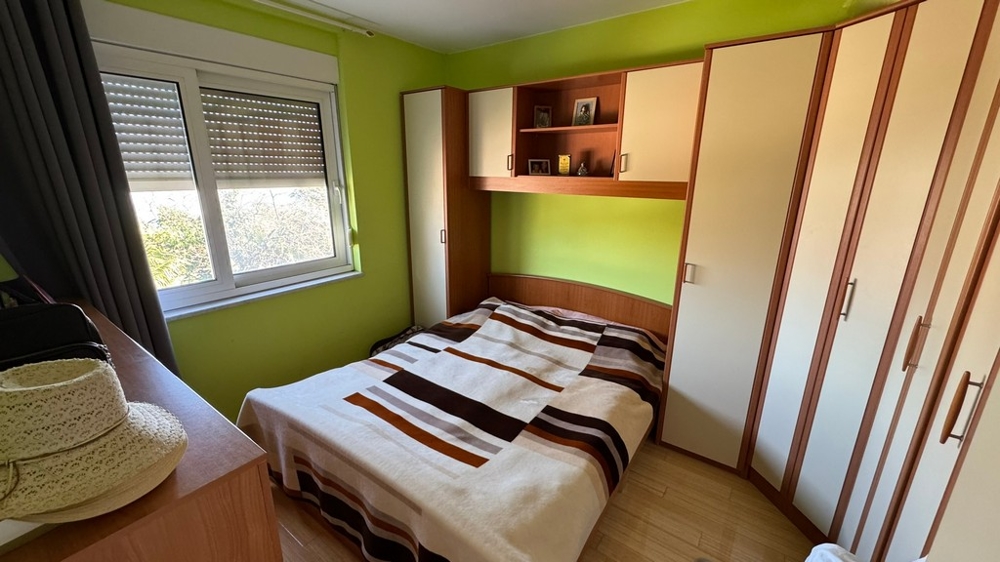 Chambre avec lit double et placards encastrés, murs verts