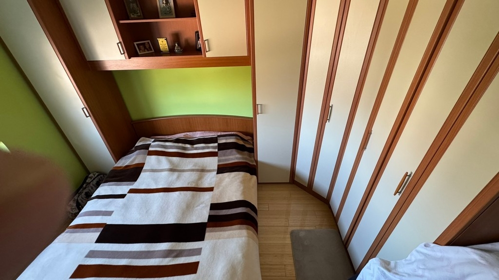 Chambre avec armoire et rangements au-dessus du lit