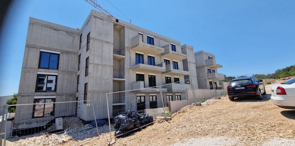 Gros œuvre en béton avec clôture de chantier et fouilles devant