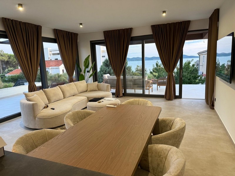 Séjour et coin repas ouverts avec terrasse et vue mer