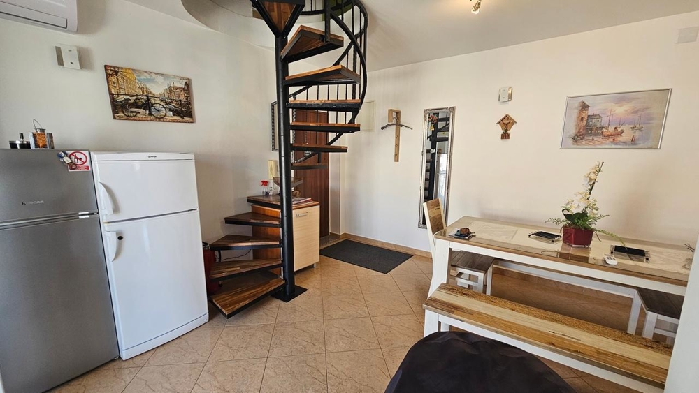 Séjour avec escalier en colimaçon et réfrigérateur