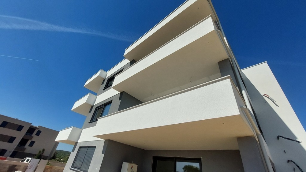 Immeuble neuf blanc avec dalles de balcon en saillie vu d'en bas